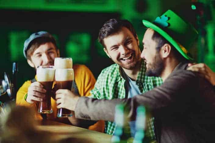 Men tossing glasses of beer in a bar. - corny jokes