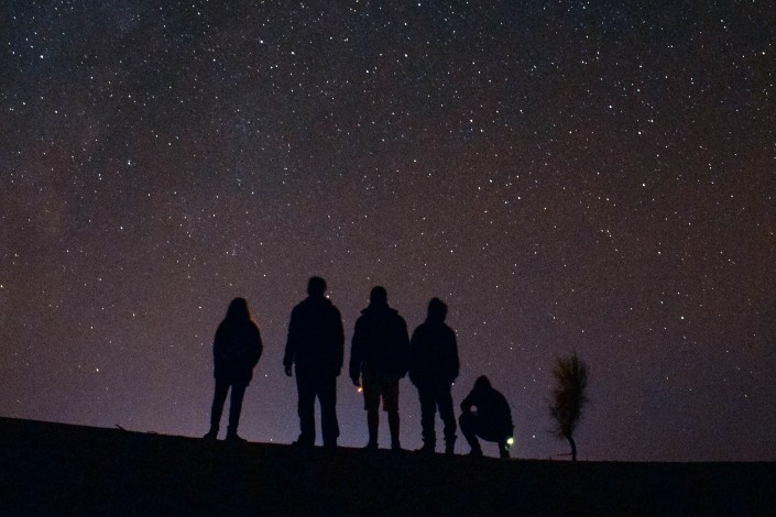 five people looking at the sky