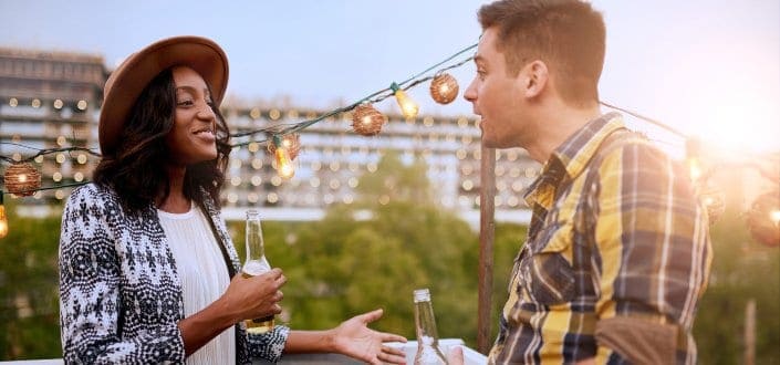 Man and woman talking while drinking outside
