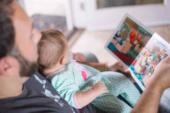 Dad reading a storybook to his baby.