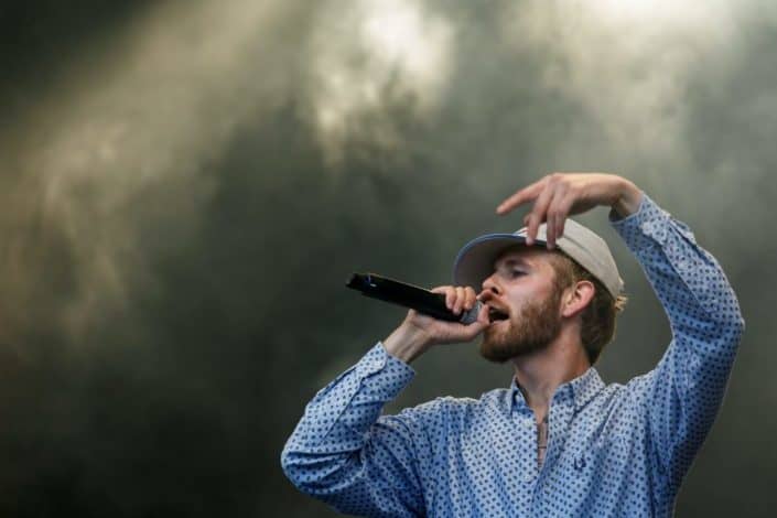 man with a microphone with smoke in the background