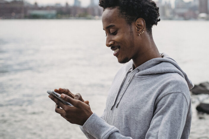 Guy smiling over something on his phone